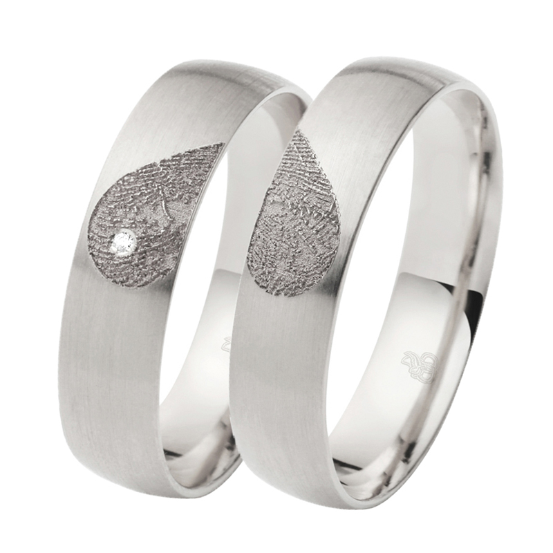 Aufnahme von Eheringen aus Weissgold mit Diamanten und Herzmuster mit Fingerabdruck