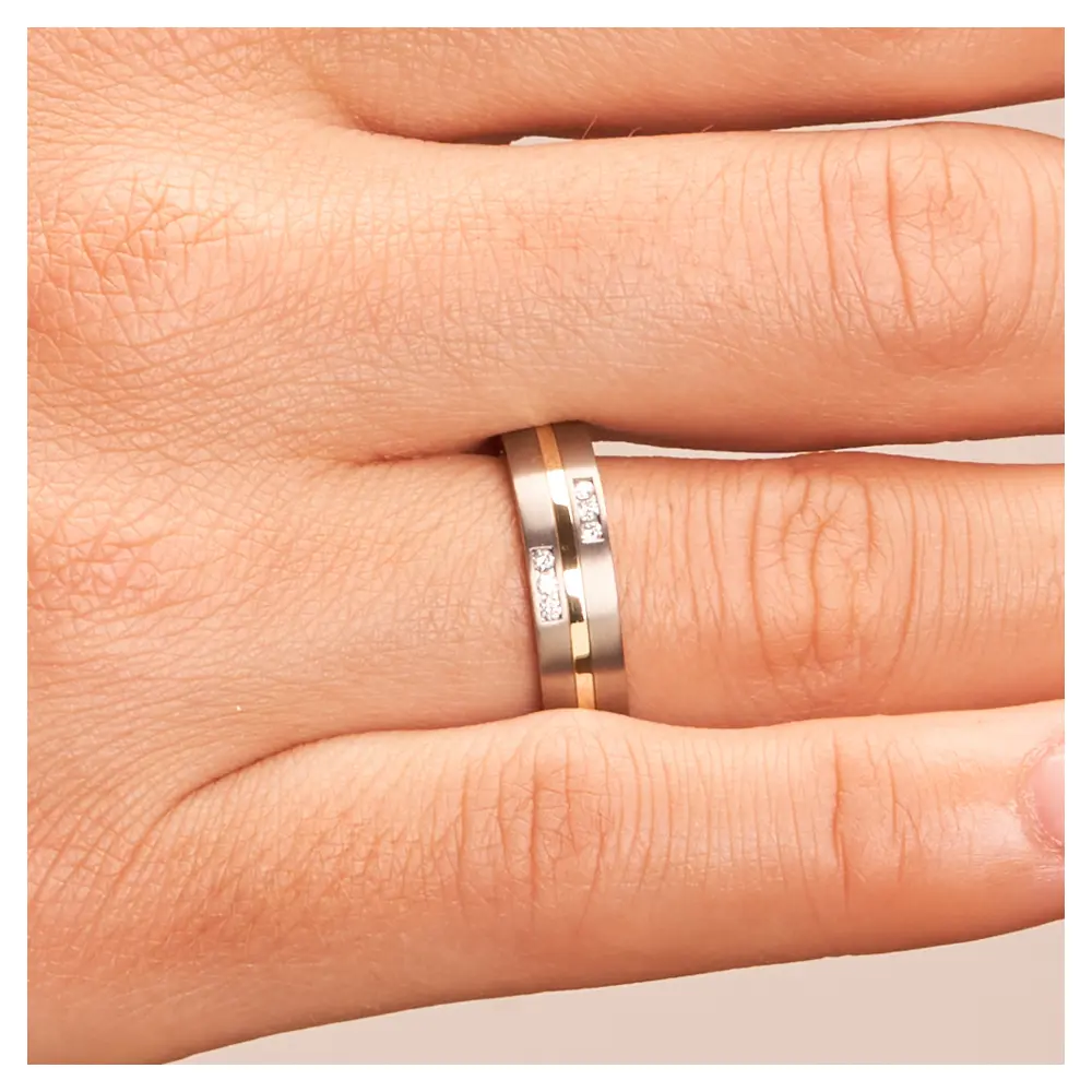 Titan & Gelbgold Trauringe mit 6 Diamanten in zwei Rillen auf Hand im Zoom