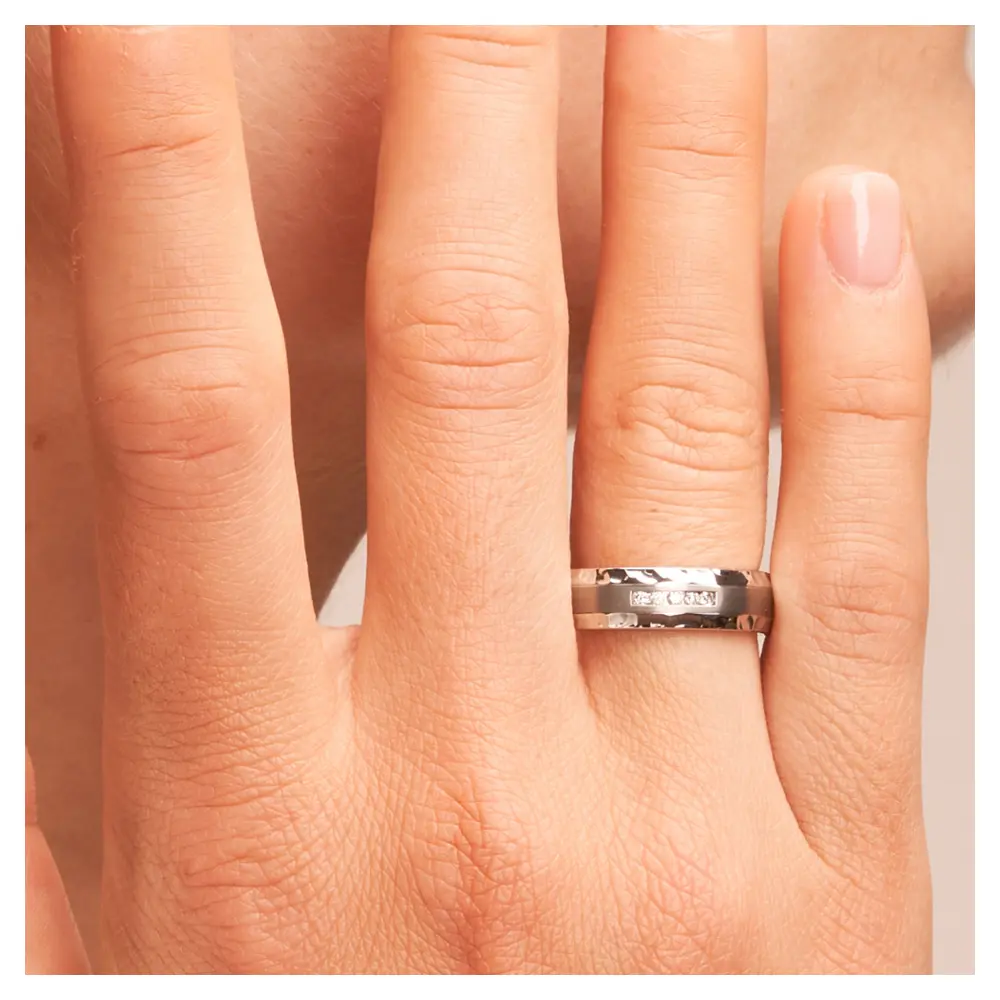 Eheringe in Edelstahl Titan mattiert mit Hammerschlag mit 5 Diamanten auf Hand am Gesicht im Zoom