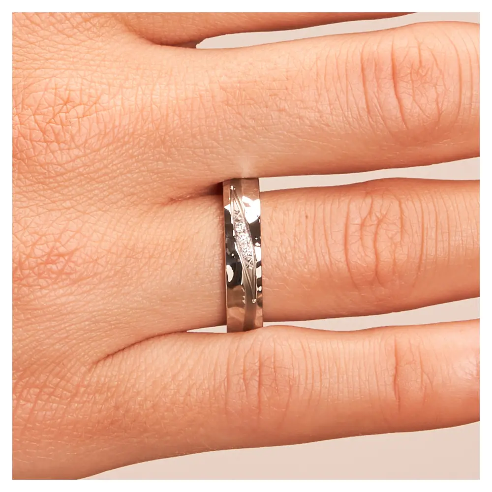 Eheringe in Edelstahl Titan mit Hammerschlag und 3 Diamanten auf Hand im Zoom