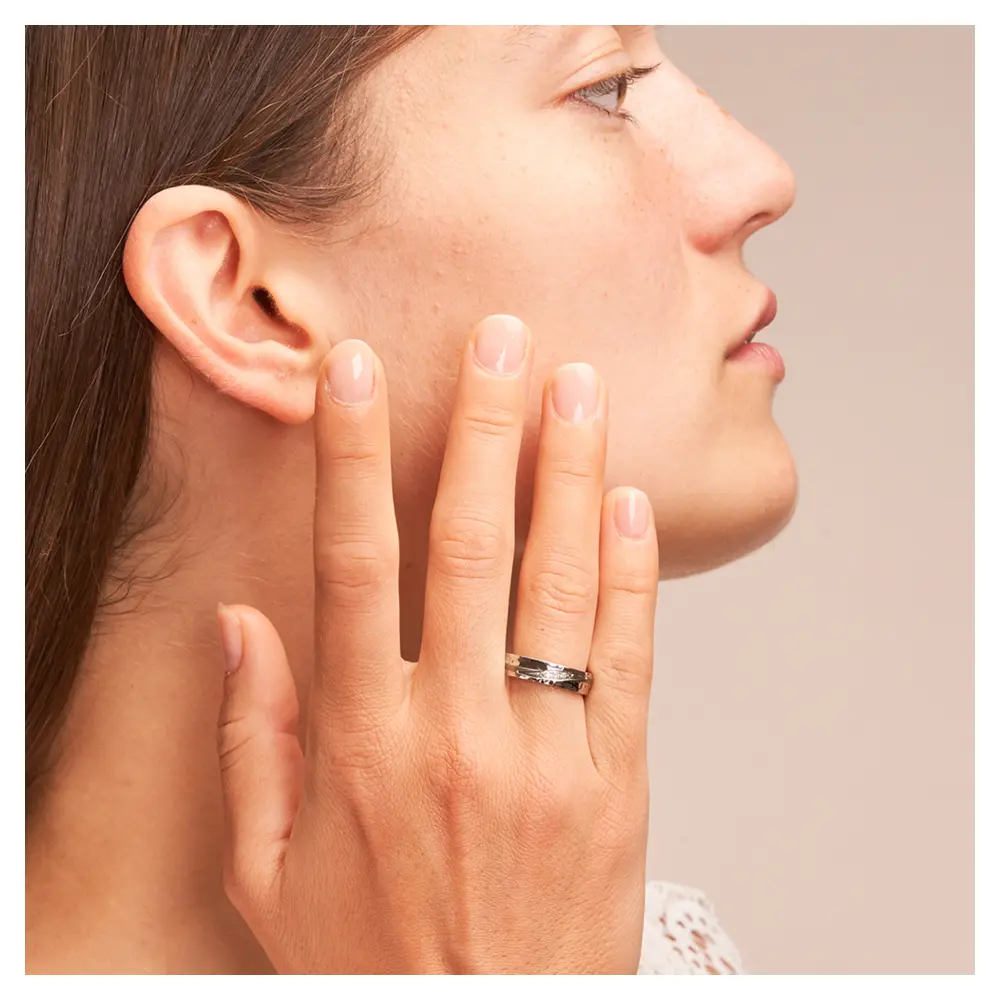 Eheringe in Edelstahl Titan mit Hammerschlag und 3 Diamanten auf Hand am Gesicht