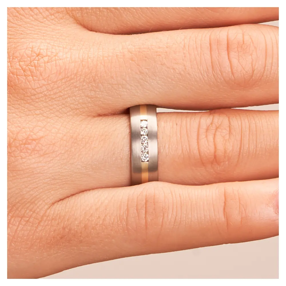 Titan Eheringe mit Gelbgoldstreifen und 5 Diamanten auf Hand im Zoom