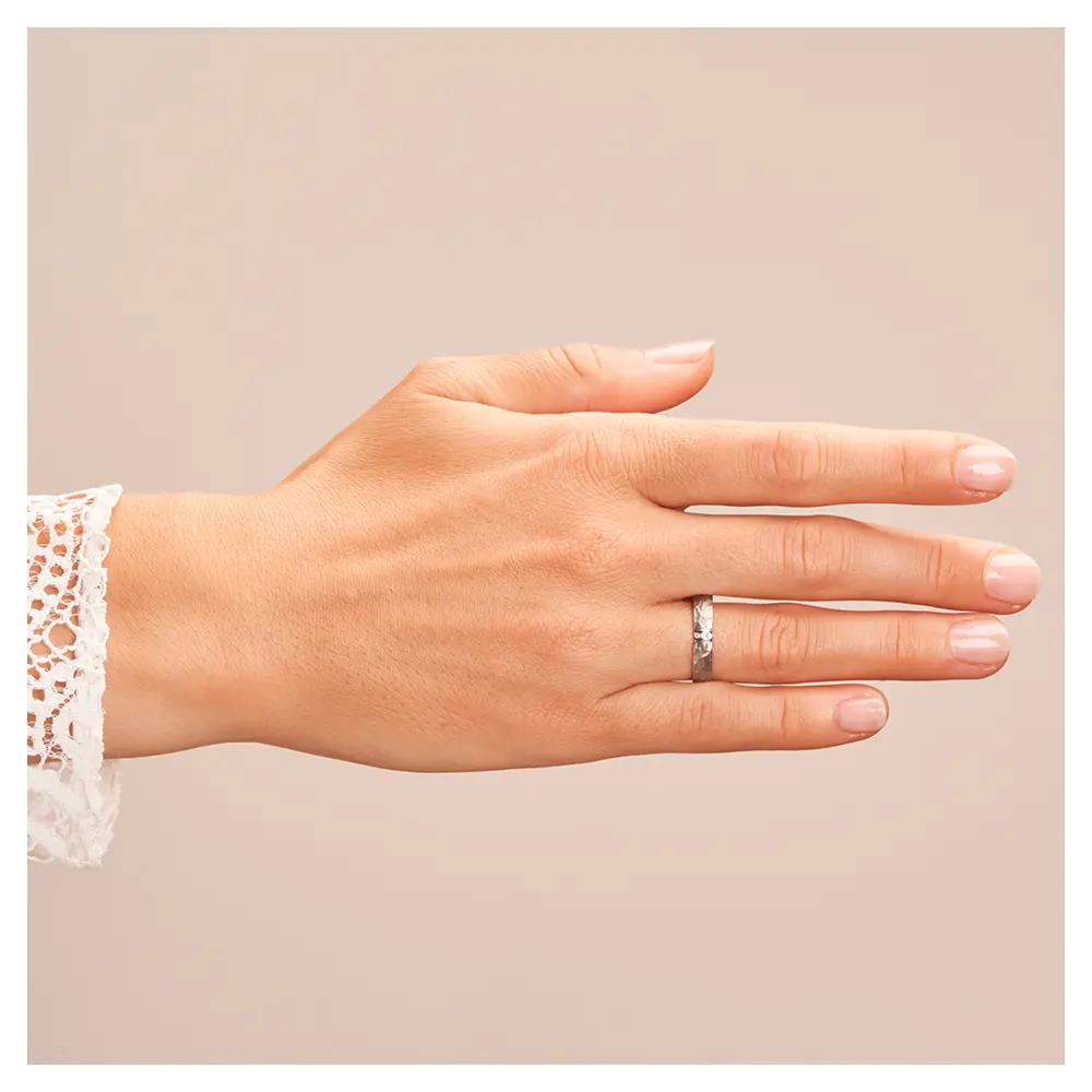 Eheringen aus Edelstahl mit gehämmerter Oberfläche und drei Diamanten auf Hand