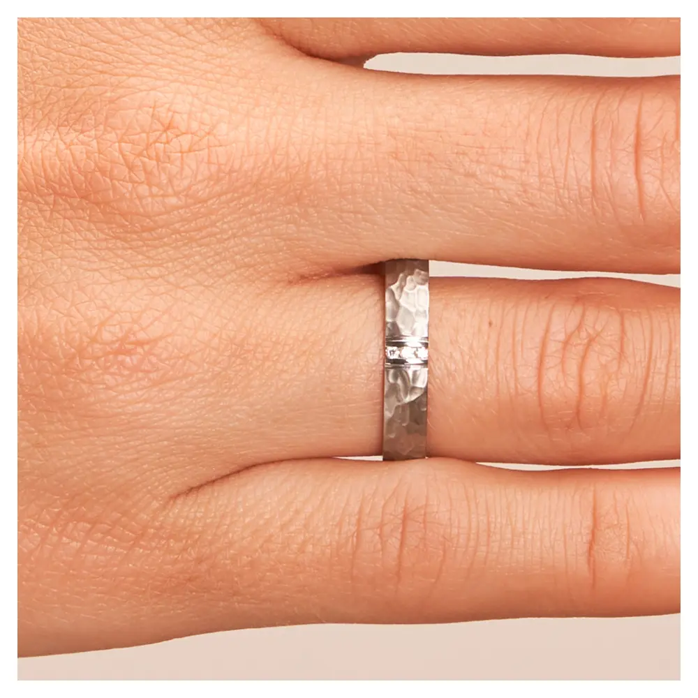 Eheringen aus Edelstahl mit gehämmerter Oberfläche und drei Diamanten auf Hand im Zoom
