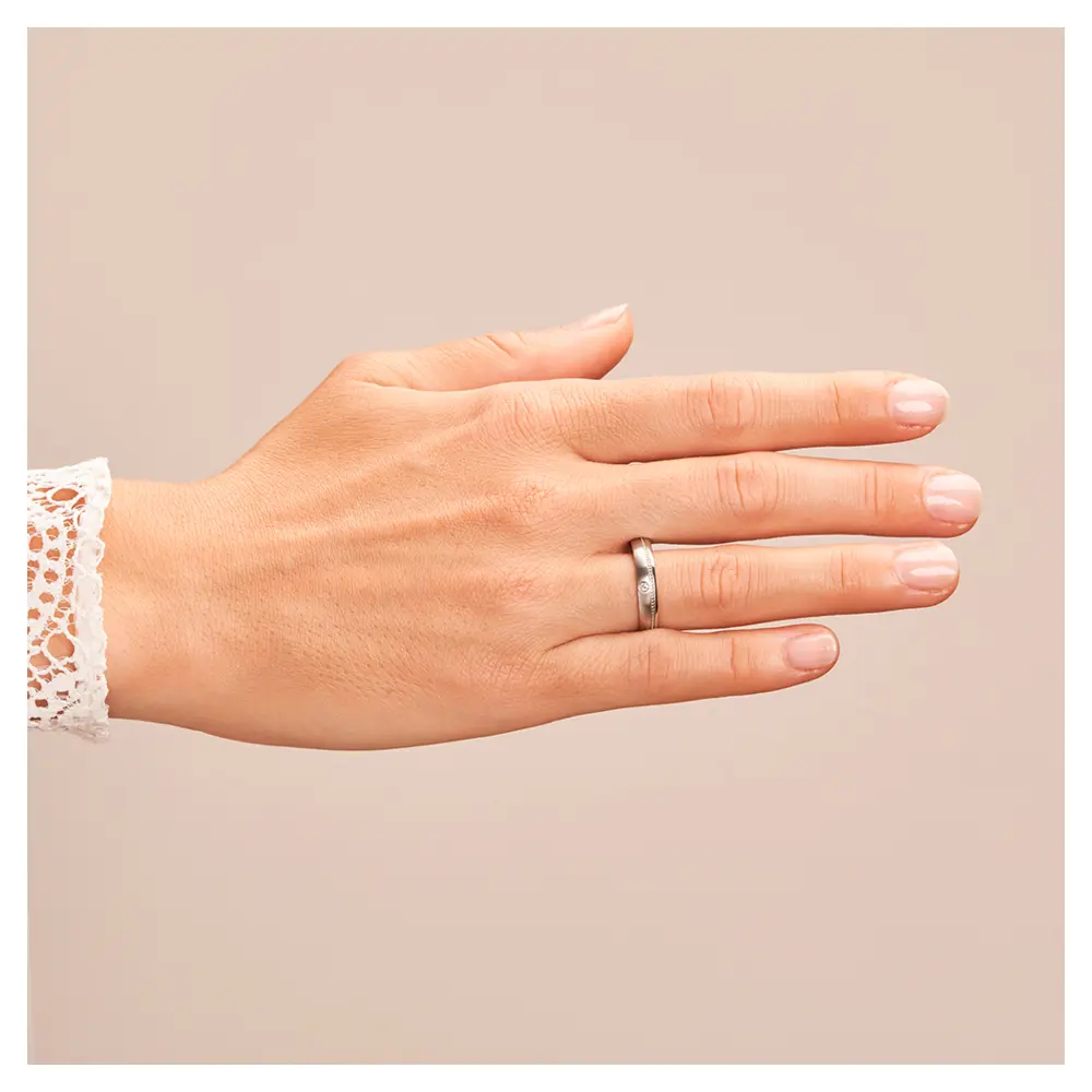 Eheringe aus Edelstahl mit Millgriff Muster und Diamanten auf Hand