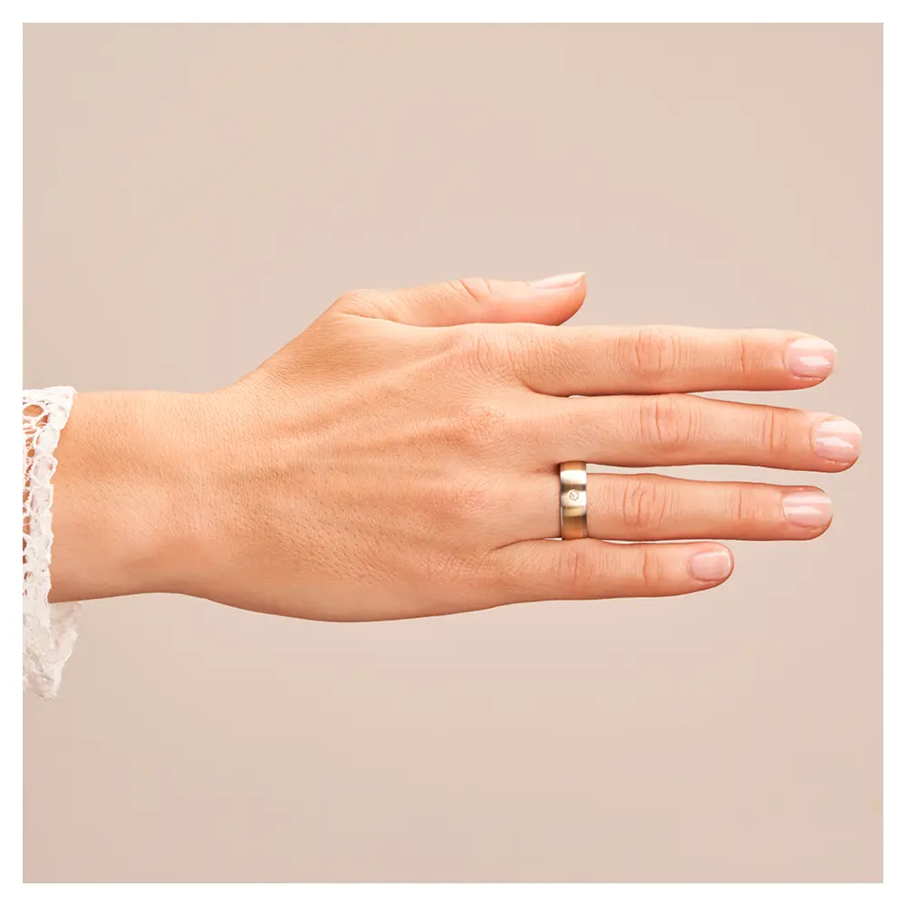 Stahl und Gelbgold Eheringe matt mit Diamanten auf Hand