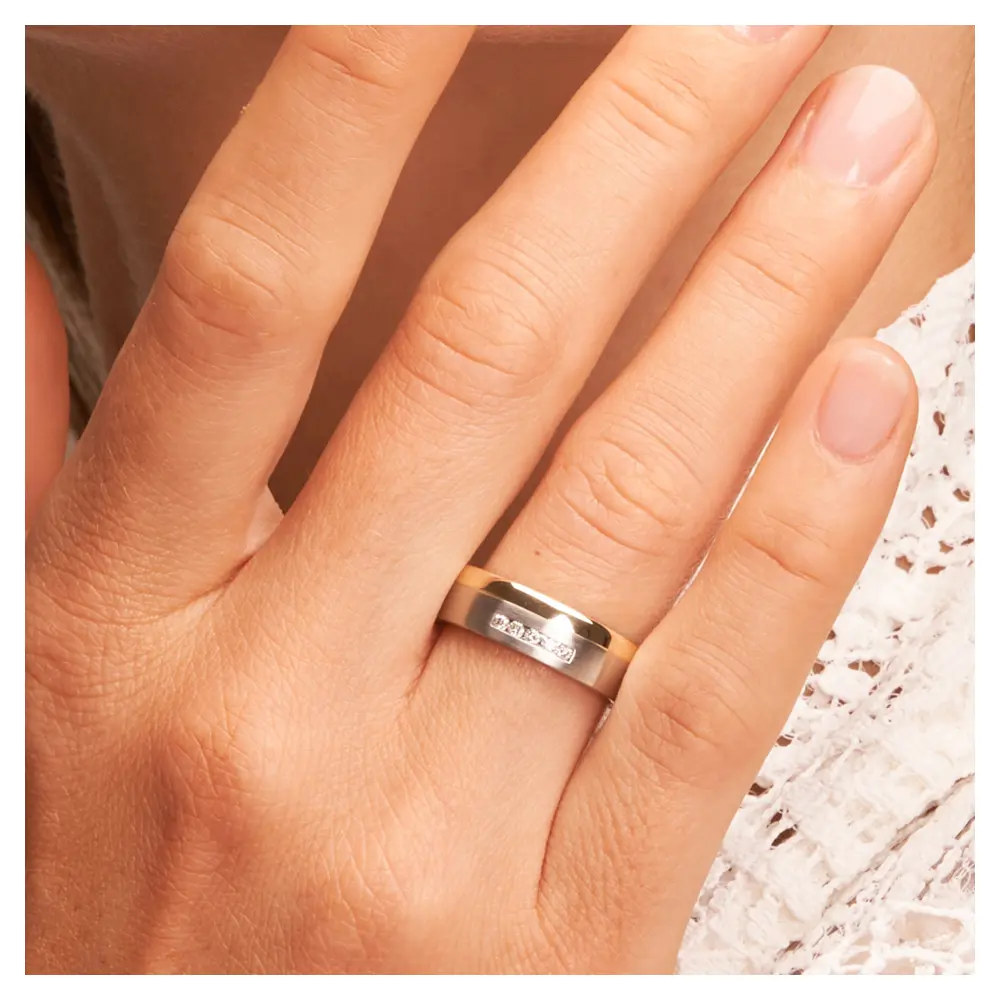 Stahl & Gelbgold Ehering mit Diamanten auf Hand im Gesicht im Zoom