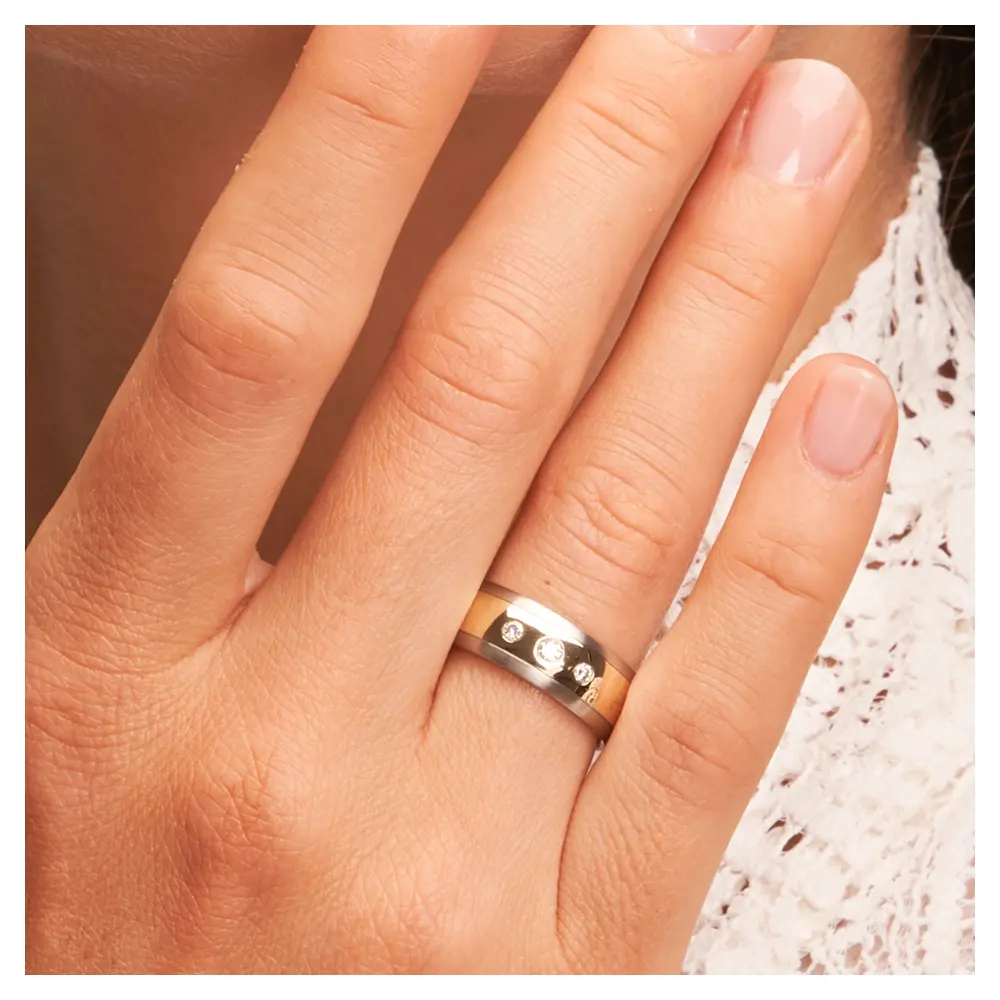 Stahl & Gelbgold Ehering Trauring mit Diamanten auf Hand im Gesicht im Zoom