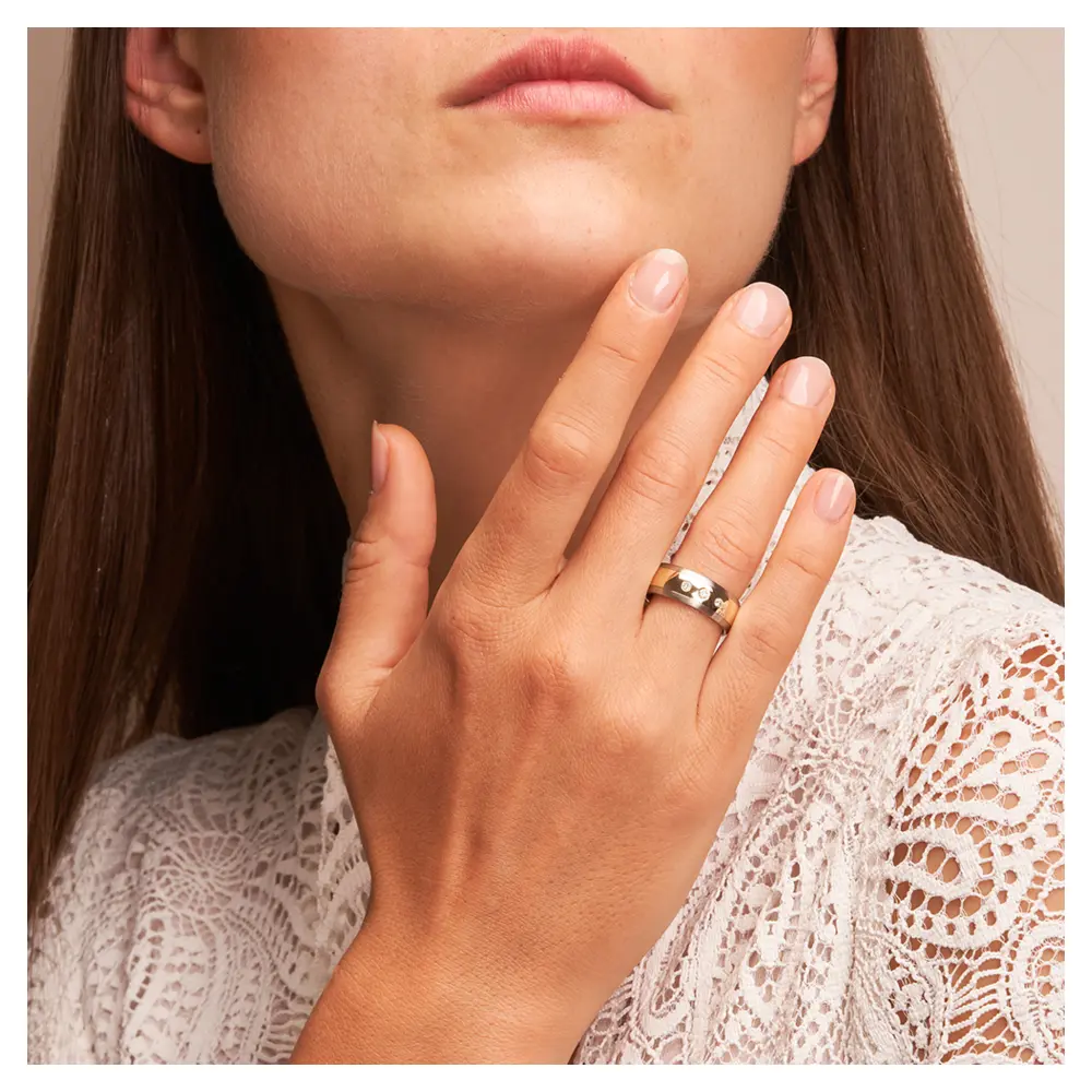 Stahl & Gelbgold Ehering Trauring mit Diamanten auf Hand im Gesicht