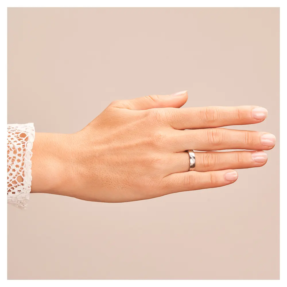 Trauring aus Edelstahl mit Roségoldstreifen und drei Diamanten auf Hand