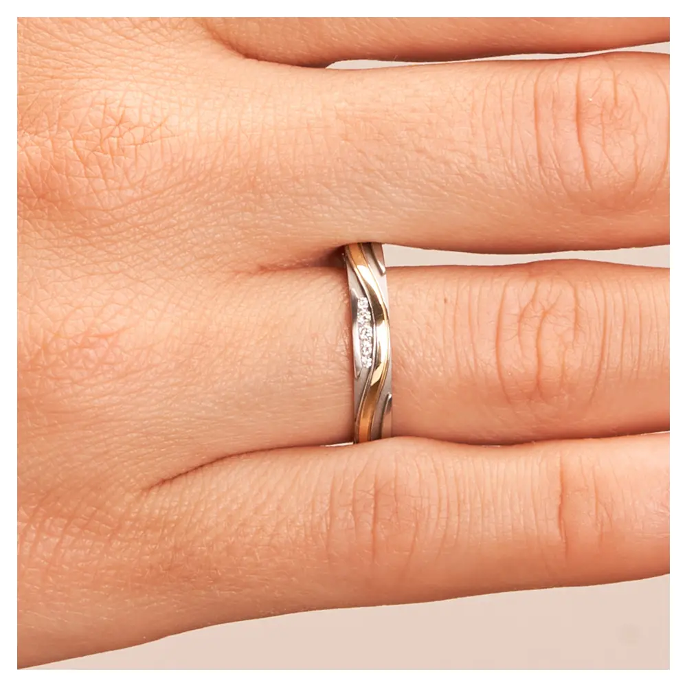 Ehering aus Edelstahl und Gelbgold mit Rillenmuster und 5 Diamanten auf Hand im Zoom