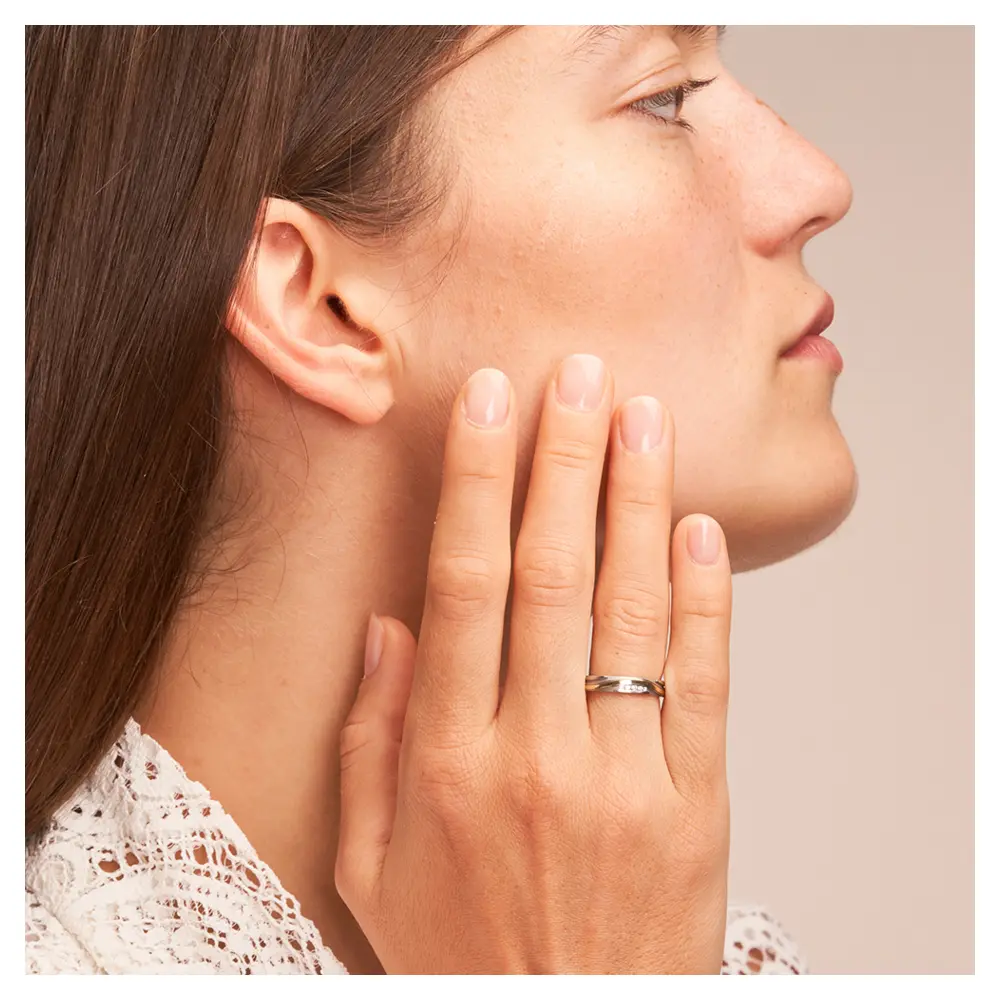 Ehering aus Edelstahl und Gelbgold mit Rillenmuster und 5 Diamanten auf Hand am Gesicht