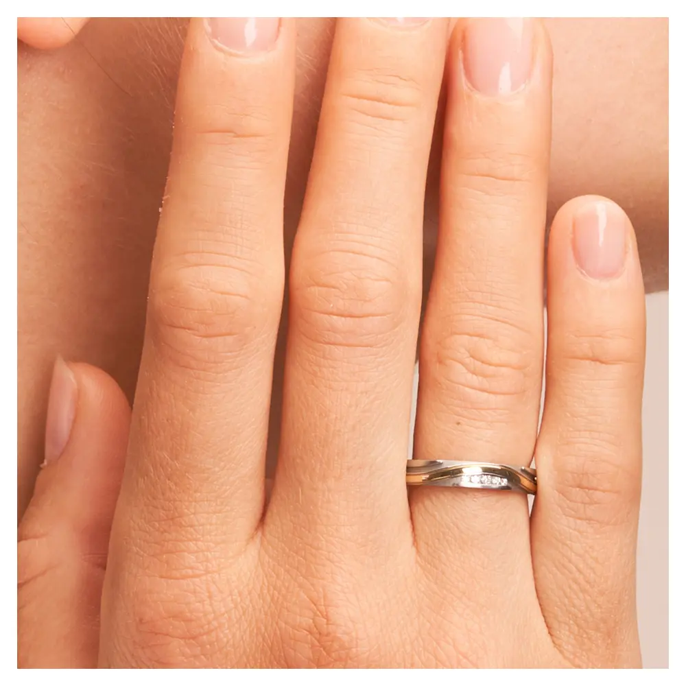 Ehering aus Edelstahl und Gelbgold mit Rillenmuster und 5 Diamanten auf Hand im Zoom