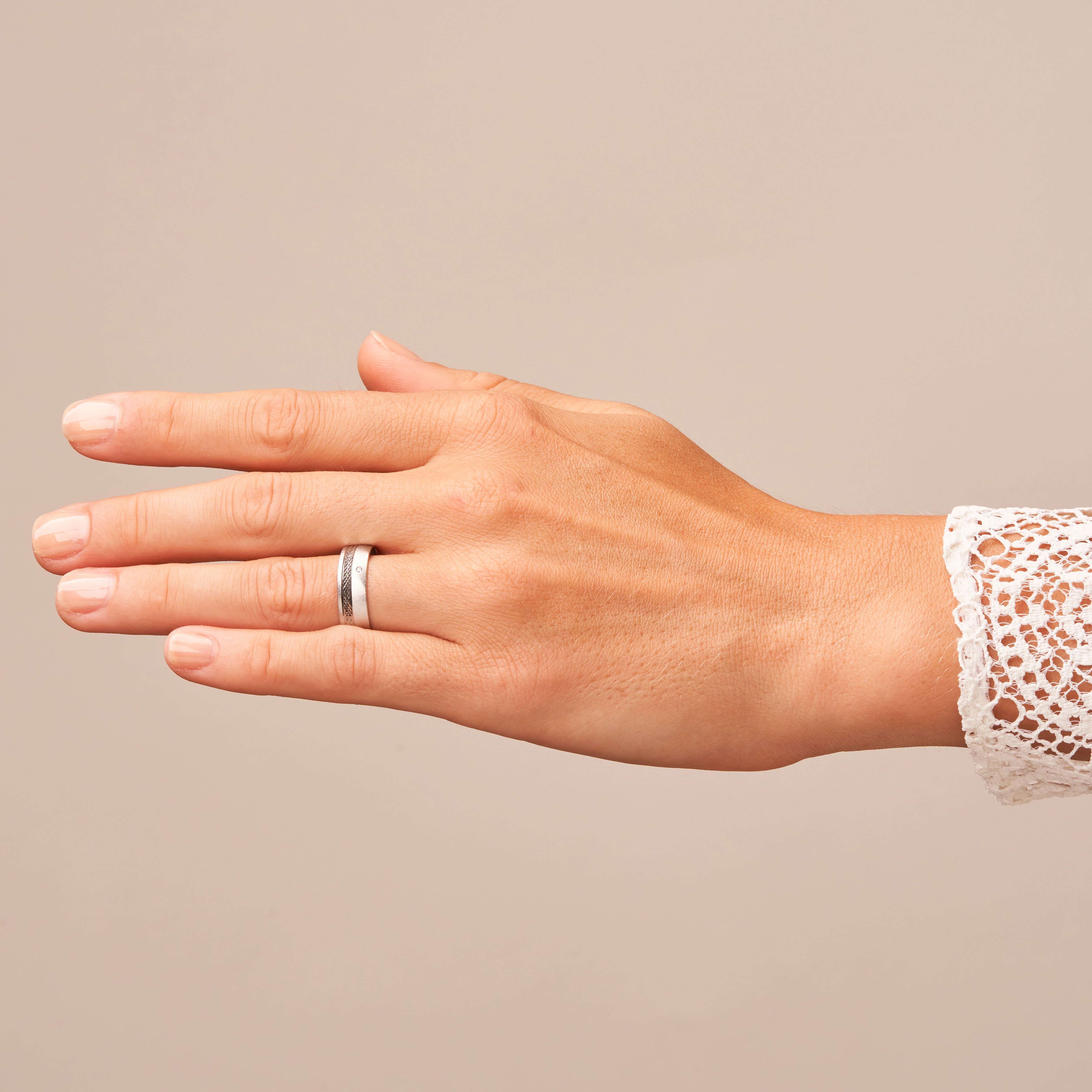 Quermattierter Platin Ehering mit gemustertem Streifen und Diamanten auf Hand