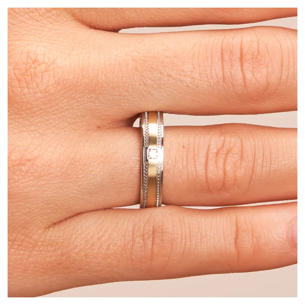 Ehering aus Edelstahl & Gelbgold in romatischem Design mit Stein auf Hand im Zoom