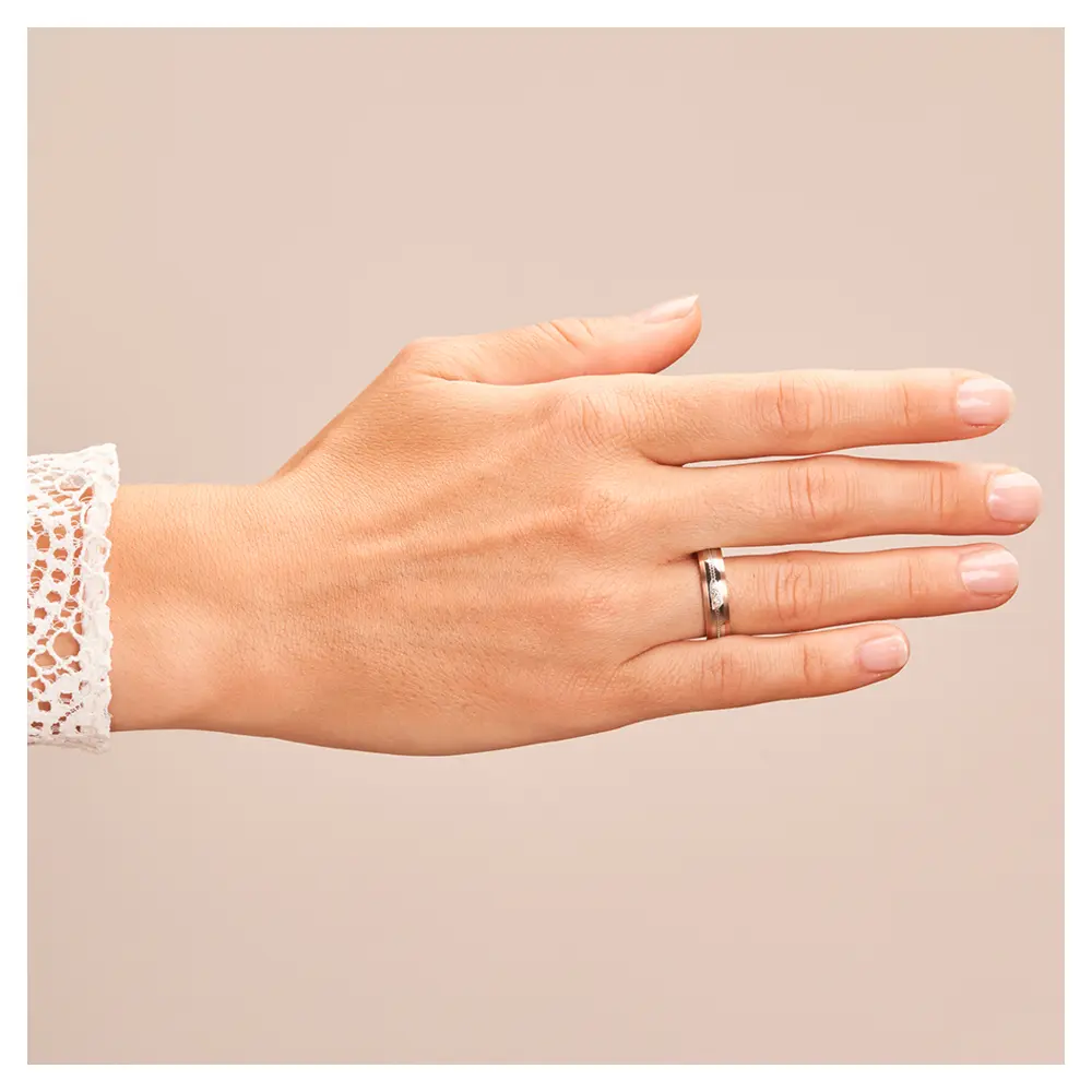 Ehering aus Edelstahl mit Roségoldrändern und drei Diamanten auf Hand