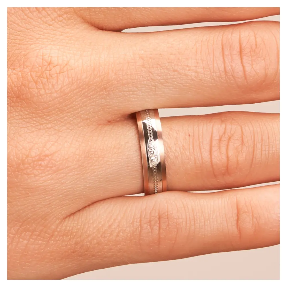 Ehering aus Edelstahl mit Roségoldrändern und drei Diamanten auf Hand im Zoom