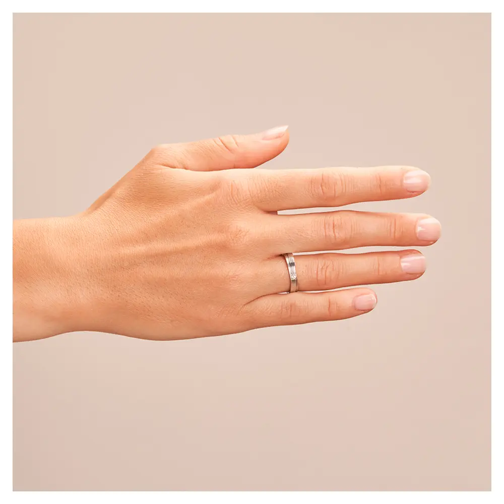 In Stufen gestaltete Eheringe aus 925er Silber mit Diamanten und Rillen auf Hand