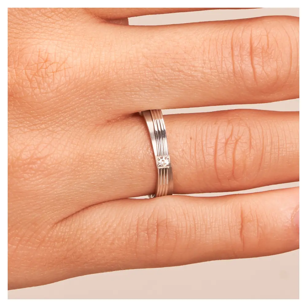 In Stufen gestaltete Eheringe aus 925er Silber mit Diamanten und Rillen auf Hand im Zoom
