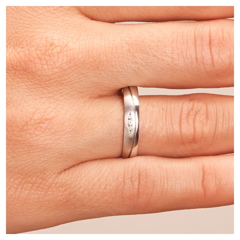 Ehering aus mattem und poliertem 925er Silber mit drei Diamanten in Vertiefung auf Hand im Zoom