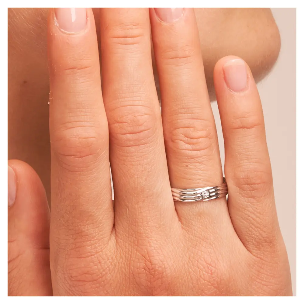 Ehering mit Rillen aus poliertem 925er Silber mit Diamanten auf Hand am Gesicht im Zoom