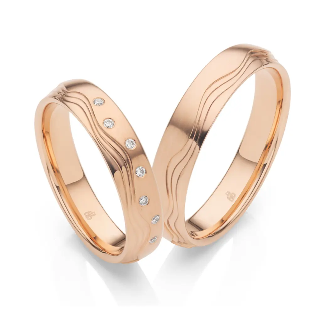 Polierte Eheringe Roségold mit 7 einzeln gefassten Diamanten und Wellendesign
