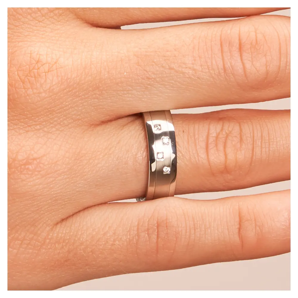Stahl Eheringe mit 4 Diamanten in Schachtfassung auf mattem Mittelstreifen auf Hand im Zoom