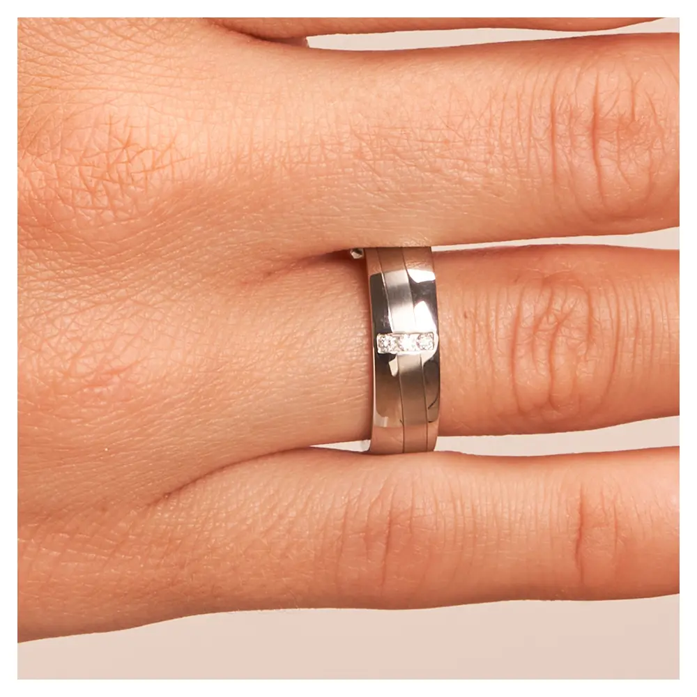Stahl Eheringe mit 3 Diamanten und schrägem Streifen auf Hand im Zoom