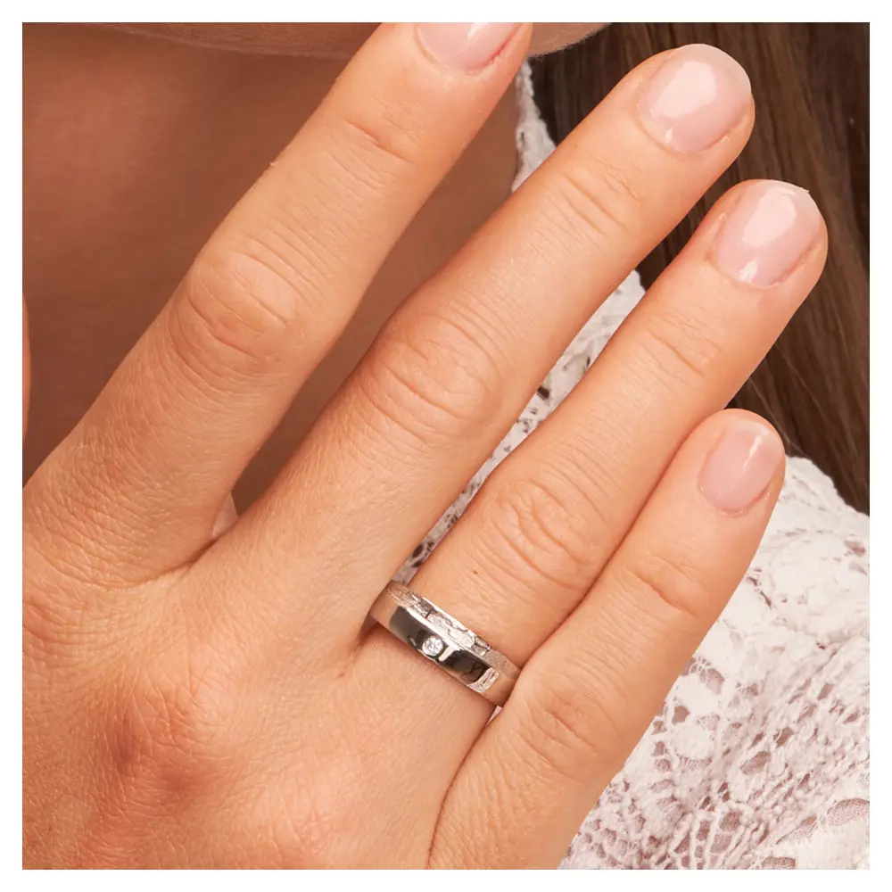 Silber 925 Trauring mit strukturiertem Seitenakzent und Diamanten auf Hand am Gesicht im Zoom