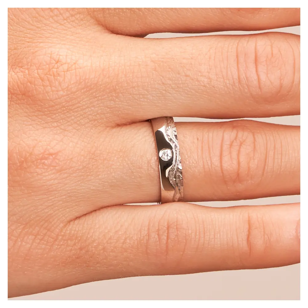 Silber 925 Trauring mit wellig designter Oberfläche und Diamanten auf Hand im Zoom