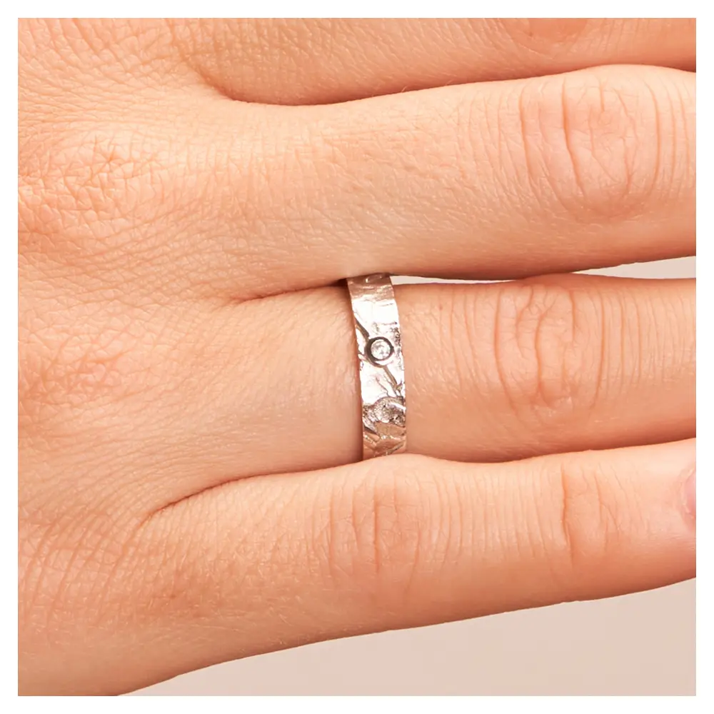 Gemusterter Silber 925 Trauring mit Diamanten und Strukturierung auf Hand im Zoom