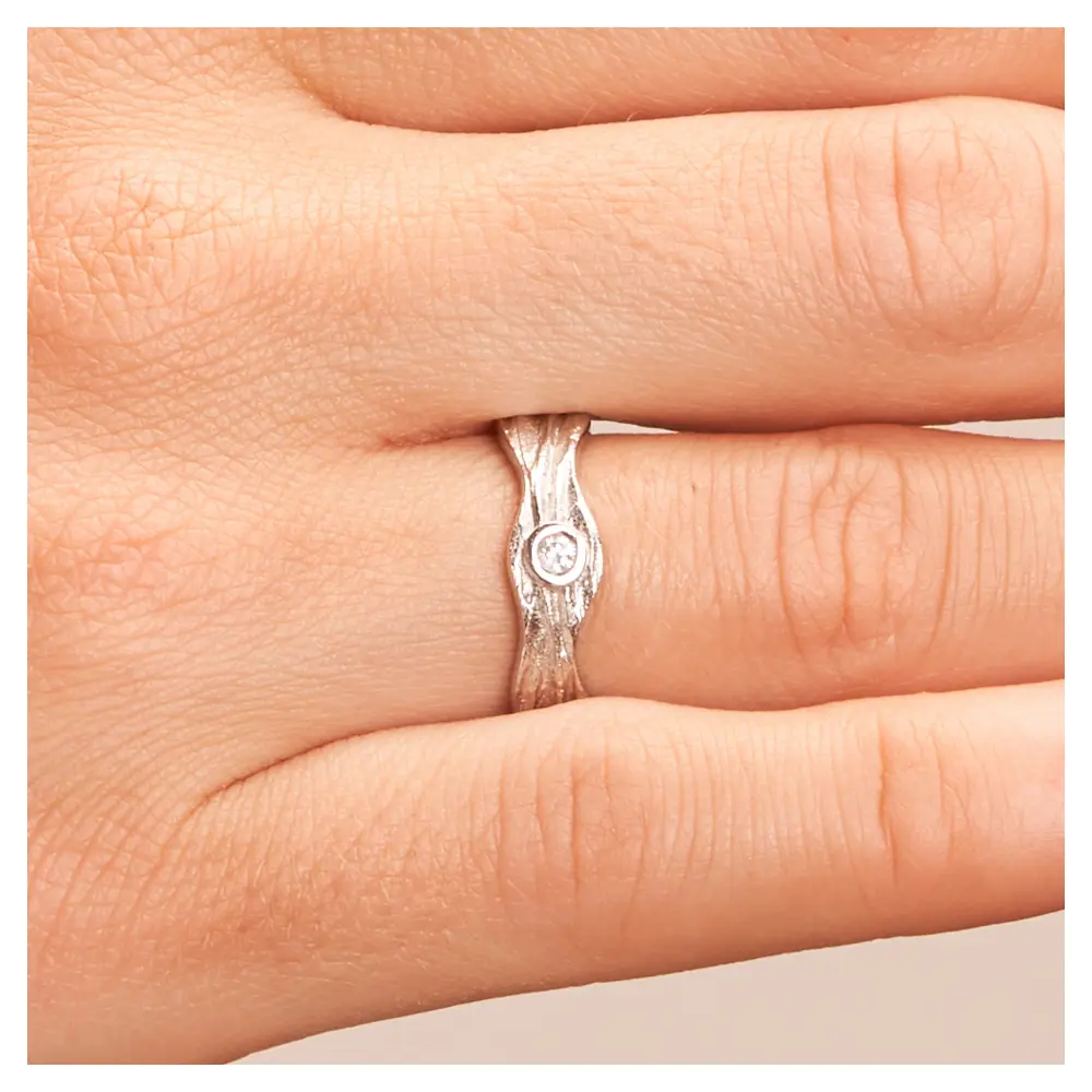 Silber 925 Trauring mit besonderer Form und Diamanten auf Hand im Zoom