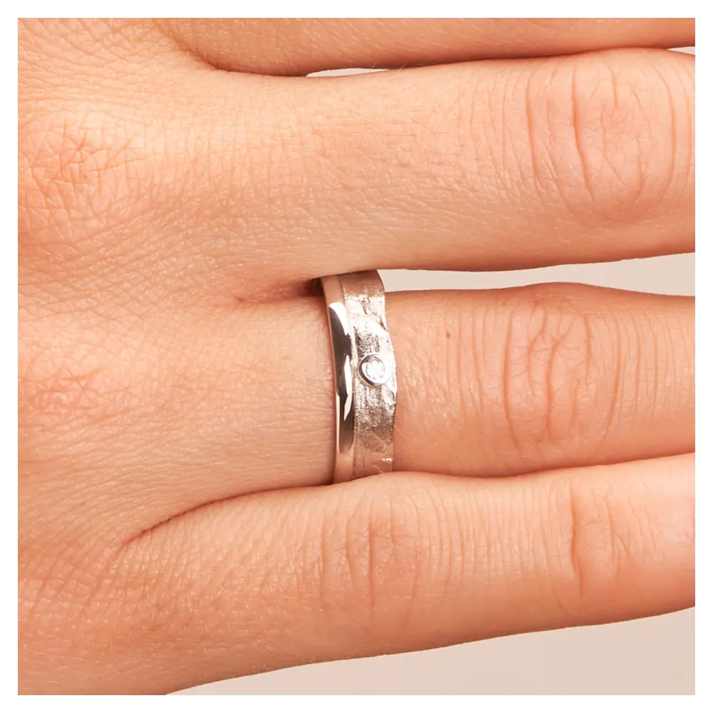 Silber 925 Trauring mit faszinierender Oberfläche und Diamanten auf Hand im Zoom