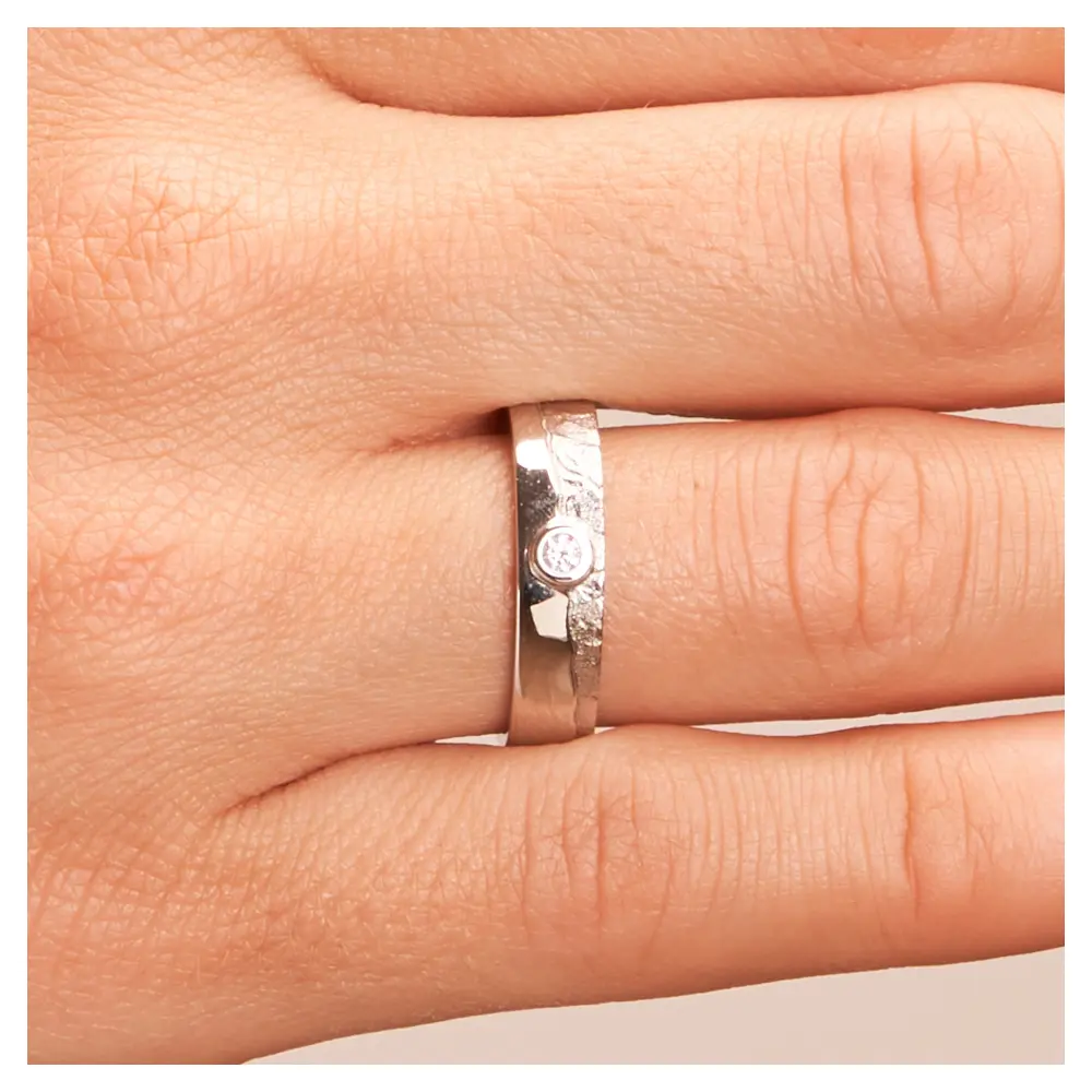 Silber 925 Trauring mit matter Strukturierung und Diamanten auf Hand im Zoom