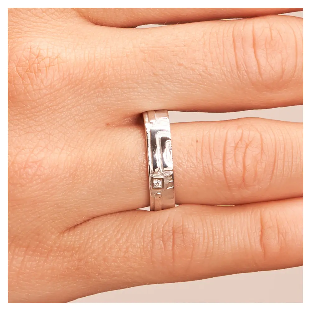 Strukturierte Silber 925 Eheringe mit Diamanten auf Hand im Zoom