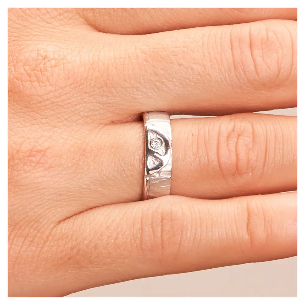 Strukturierte Silber 925 Eheringe mit Peace Zeichen und Diamanten auf Hand im Zoom