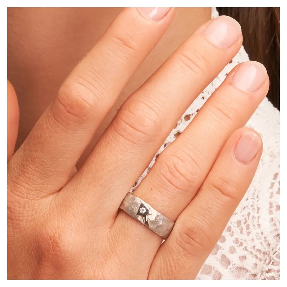 Strukturierte Silber 925 Eheringe mit Pfeilmuster Diamanten auf Hand am Gesicht