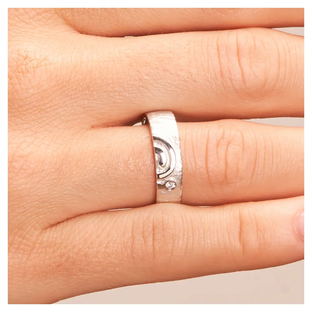 Strukturierte Silber 925 Eheringe mit ringübergreifender Spirale und Diamanten auf Hand im Zoom