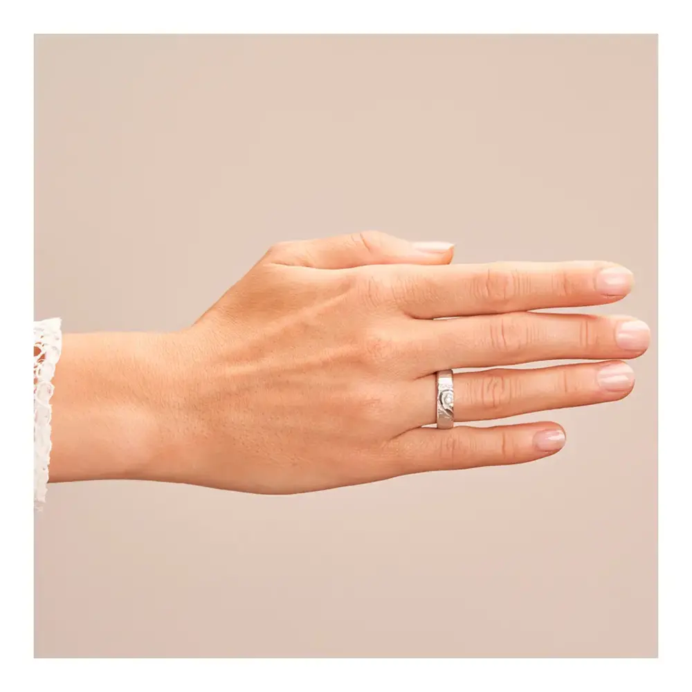 Eheringe mit ringübergreifendem Herz und Diamanten auf Hand