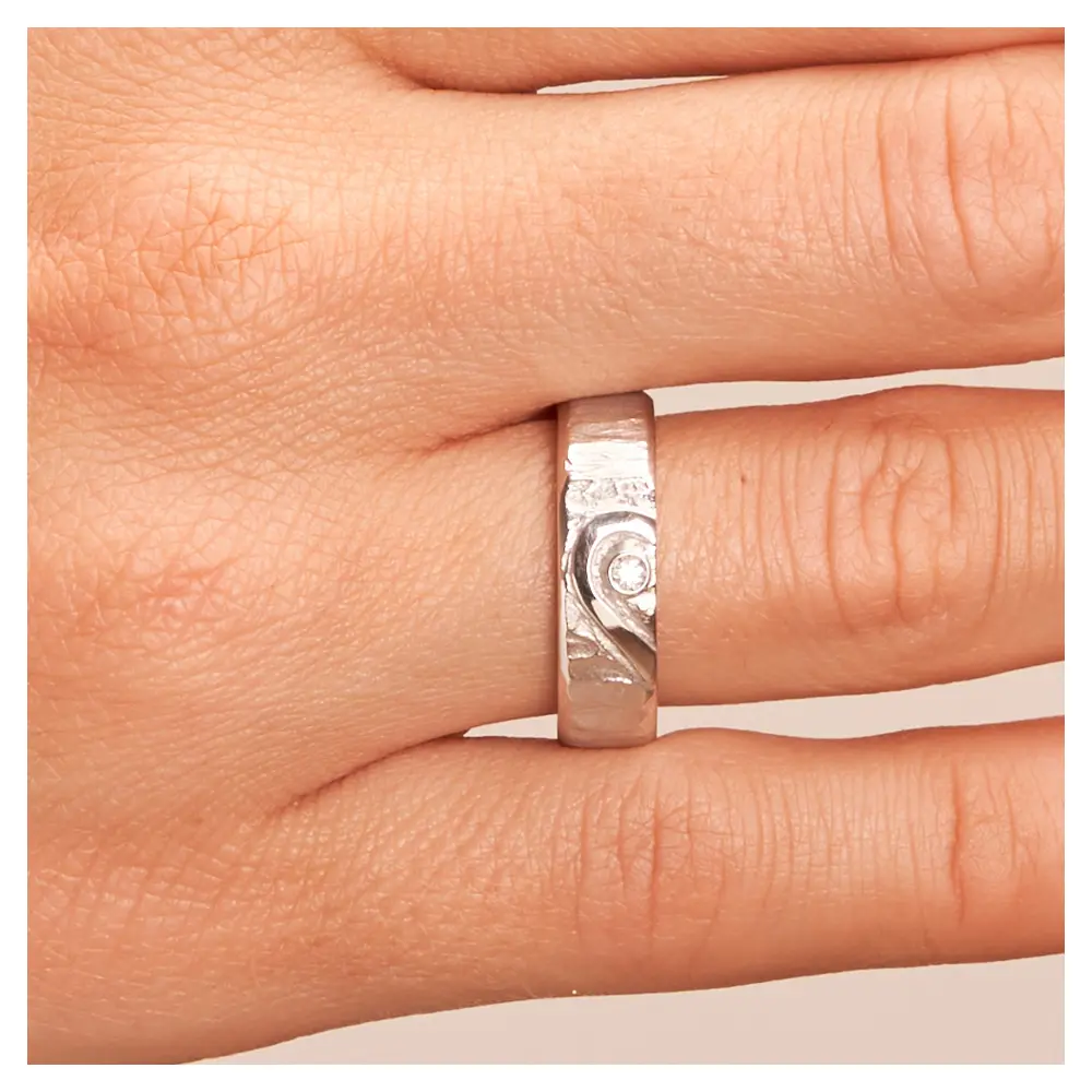 Silber 925 Eheringe mit ringübergreifendem Herz und Diamanten auf Hand im Zoom