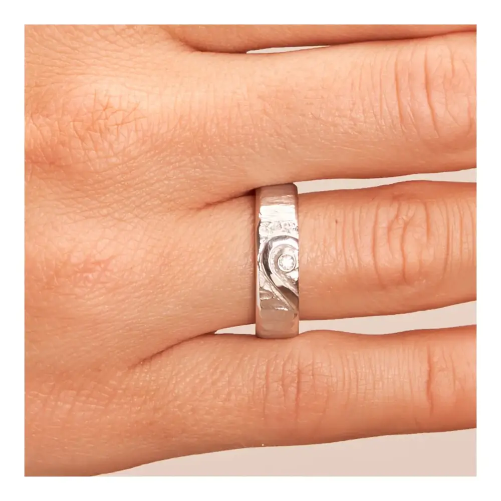 Weißgold Eheringe mit ringübergreifendem Herz und Diamanten auf Hand im Zoom