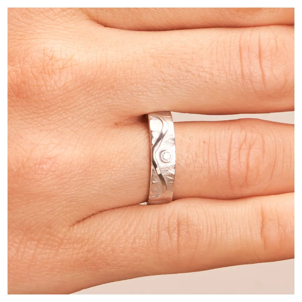 Strukturierte Silber 925 Eheringe mit Unendlichkeit Muster und Diamanten auf Hand im Zoom
