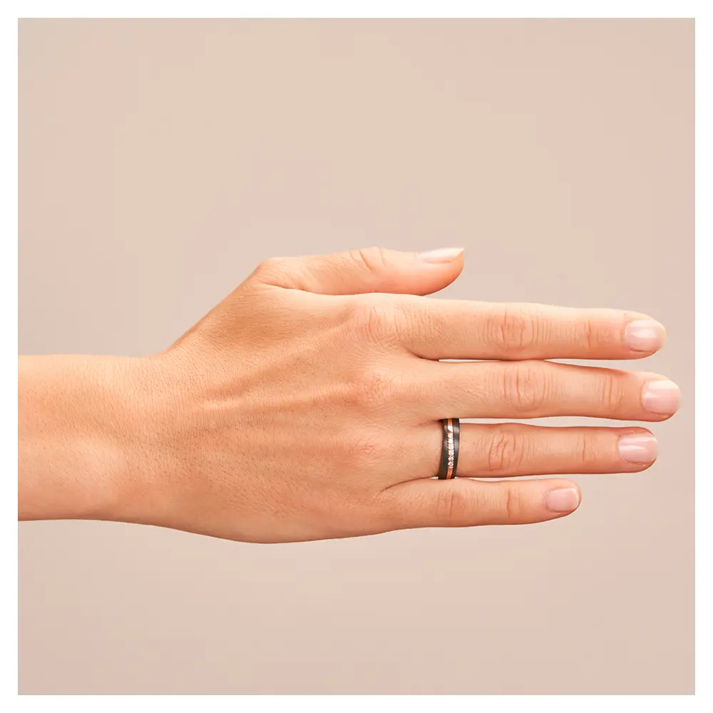 Ehering aus schwarzem Zirkonium mit poliertem Roségoldstreifen und 6 Diamanten auf Hand