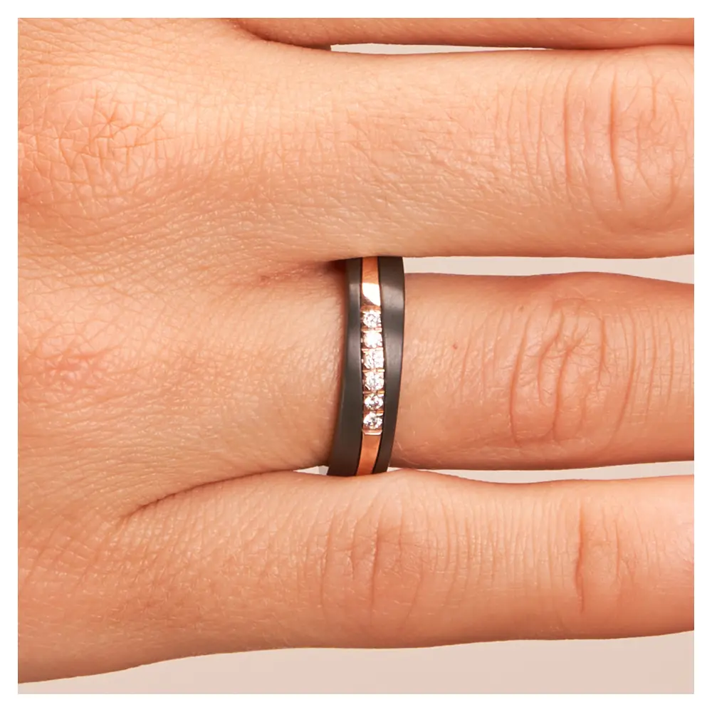 Ehering aus schwarzem Zirkonium mit poliertem Roségoldstreifen und 6 Diamanten auf Hand im Zoom