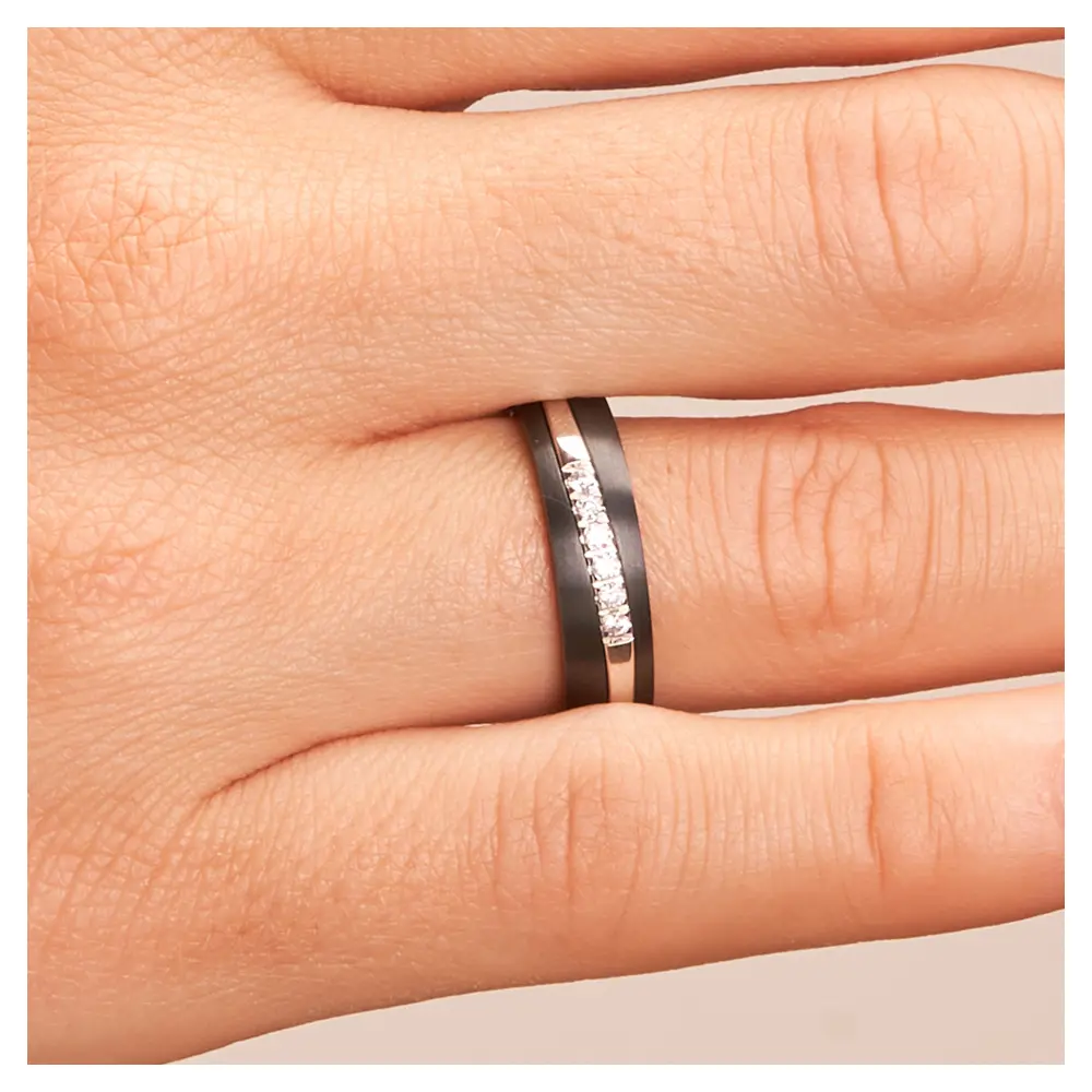 Ehering aus Weißgold & Zirkonium mit 6 Diamanten in bicolorem Design auf Hand im Zoom