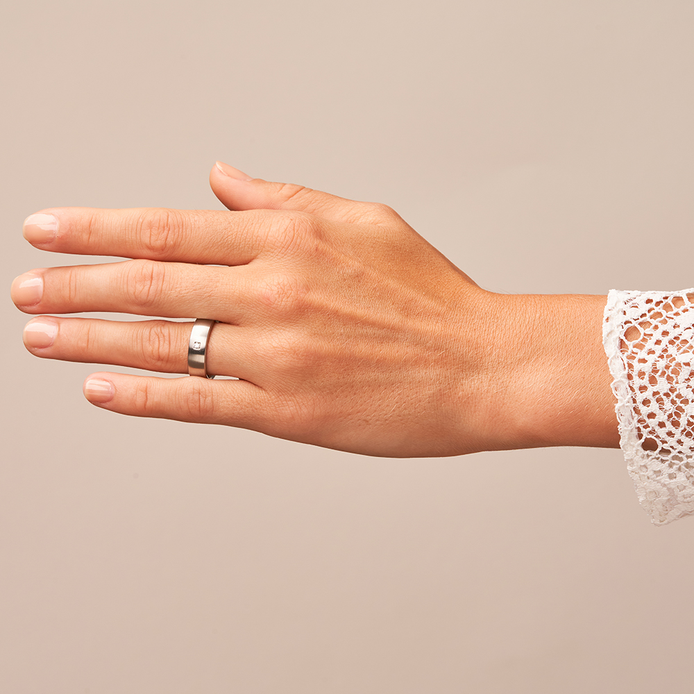 Seidenmatte Stahl Trauringe mit Diamanten auf Hand