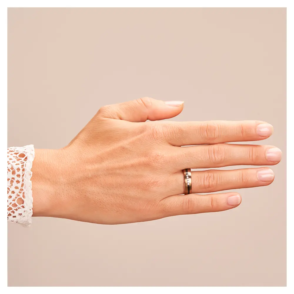 Trauring aus Roségold&Zirkonium mit fünf Diamanten und elegant geschwungenem Streifen auf Hand