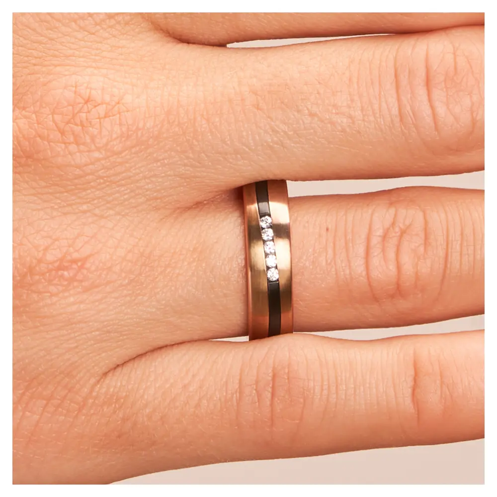 Trauring aus Roségold&Zirkonium mit fünf Diamanten und geschwungenem Streifen auf Hand im Zoom