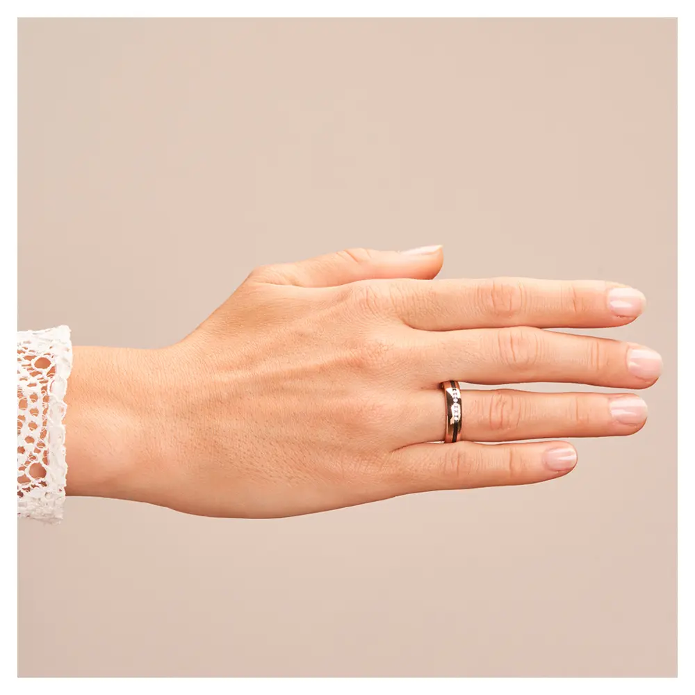 Ehering aus Roségold mit Zirkoniumstreifen und sieben Diamanten auf Hand