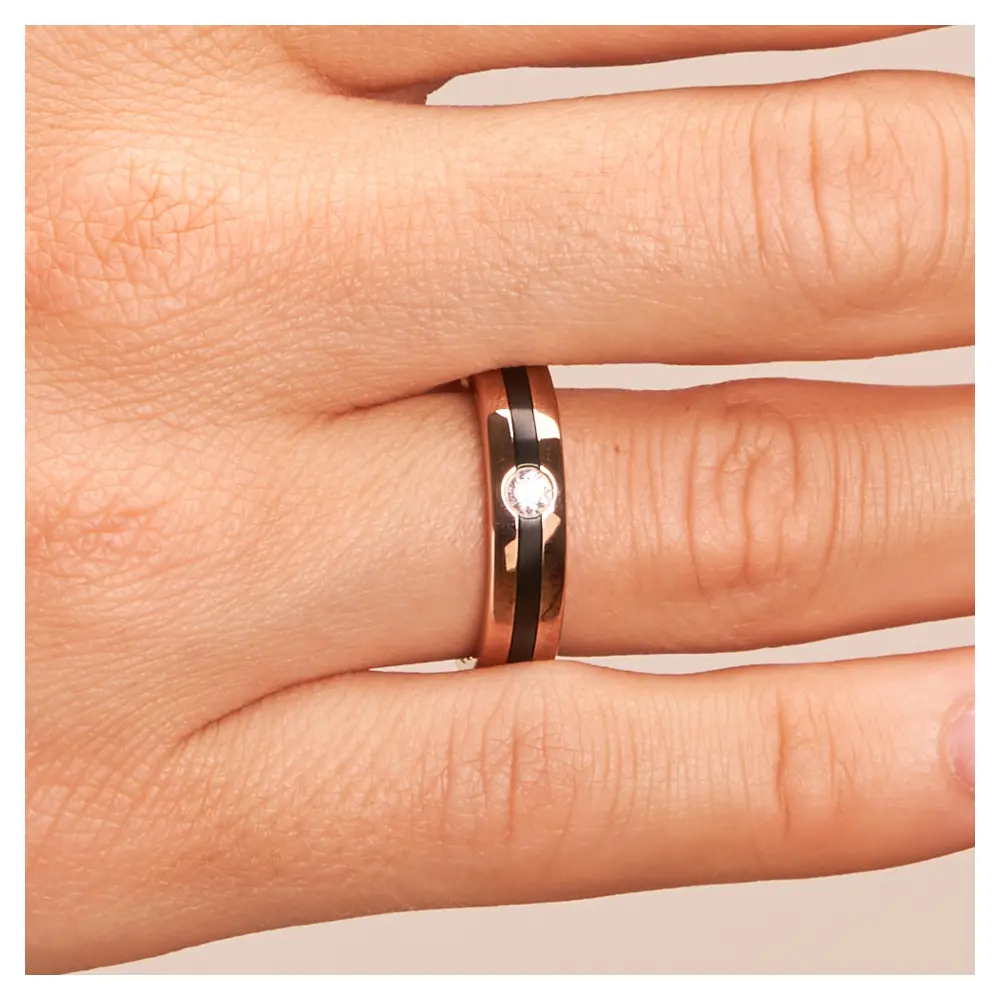 Trauring aus Roségold mit weißem Diamanten und Zirkoniumstreifen auf Hand im Zoom